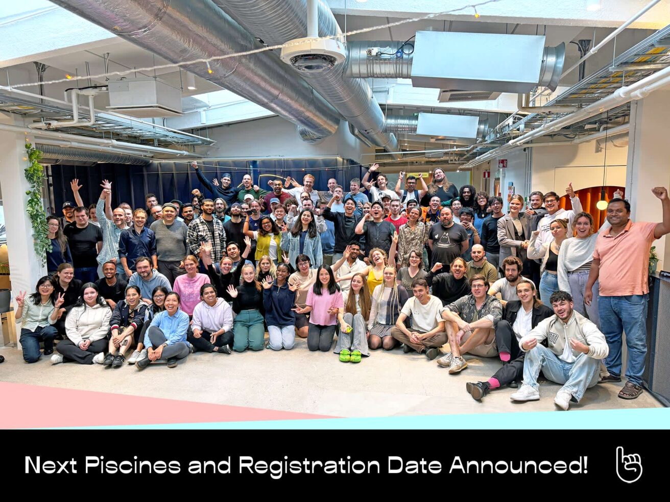 A large, enthusiastic group of people, likely Hive Helsinki students, staff, and community members, celebrating in a bright, open-plan space. Many are waving and smiling, marking the announcement of the Next Piscines and Registration Dates for 2024. This vibrant image captures the energy of the Hive Helsinki campus and its growing community, emphasizing the opportunities for coding education and tech talent development in Helsinki, Finland.