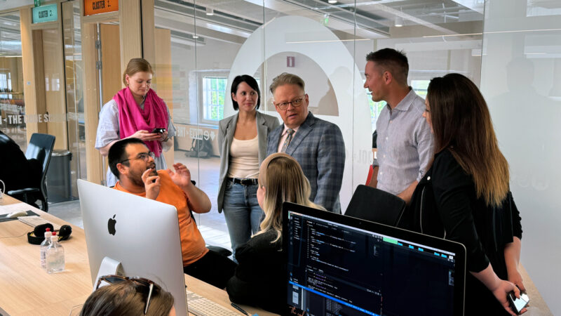 Helsinki Mayor Juhana Vartiainen and other visitors observe Hive Helsinki students actively engaged in coding and project-based learning in their modern computer lab. This image showcases a public figure's visit to the innovative tech education campus in Helsinki, highlighting Hive's contribution to futureproofing talent and digital skills in Finland.