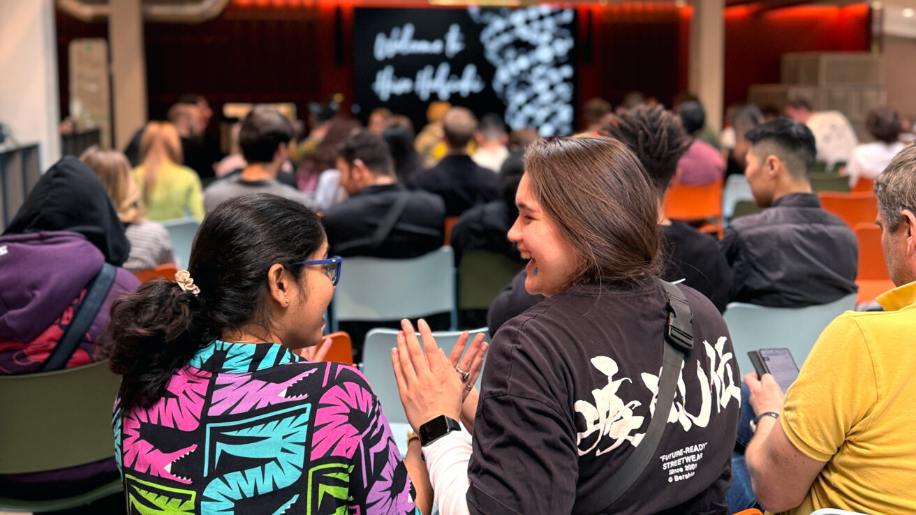 Students at Hive Helsinki welcome event sitting together, chatting, and getting ready for the program