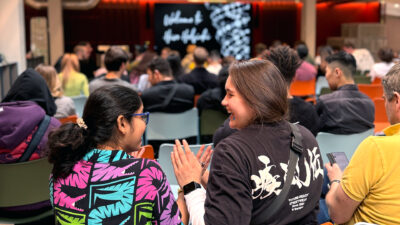 Students at Hive Helsinki welcome event sitting together, chatting, and getting ready for the program