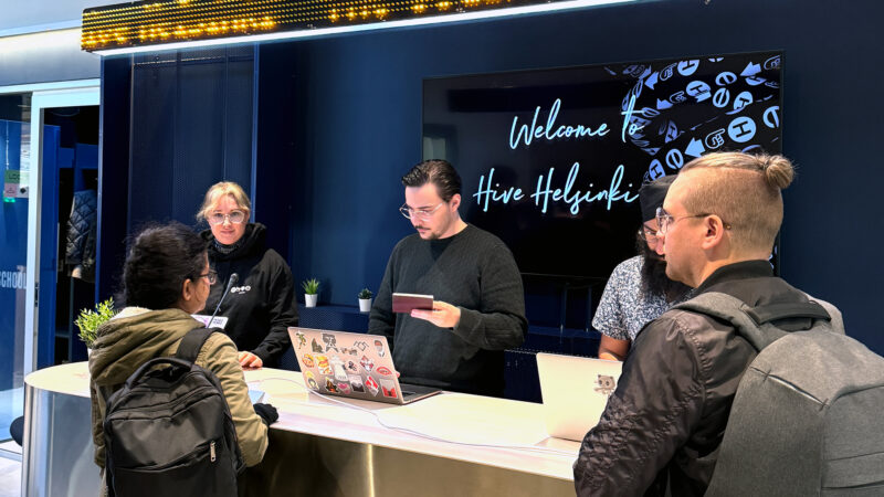Students being welcomed at the Hive Helsinki reception desk with staff offering guidance and support