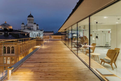 Evening view from the Reaktor Helsinki office showing the Helsinki Cathedral and modern working space with wooden deck.