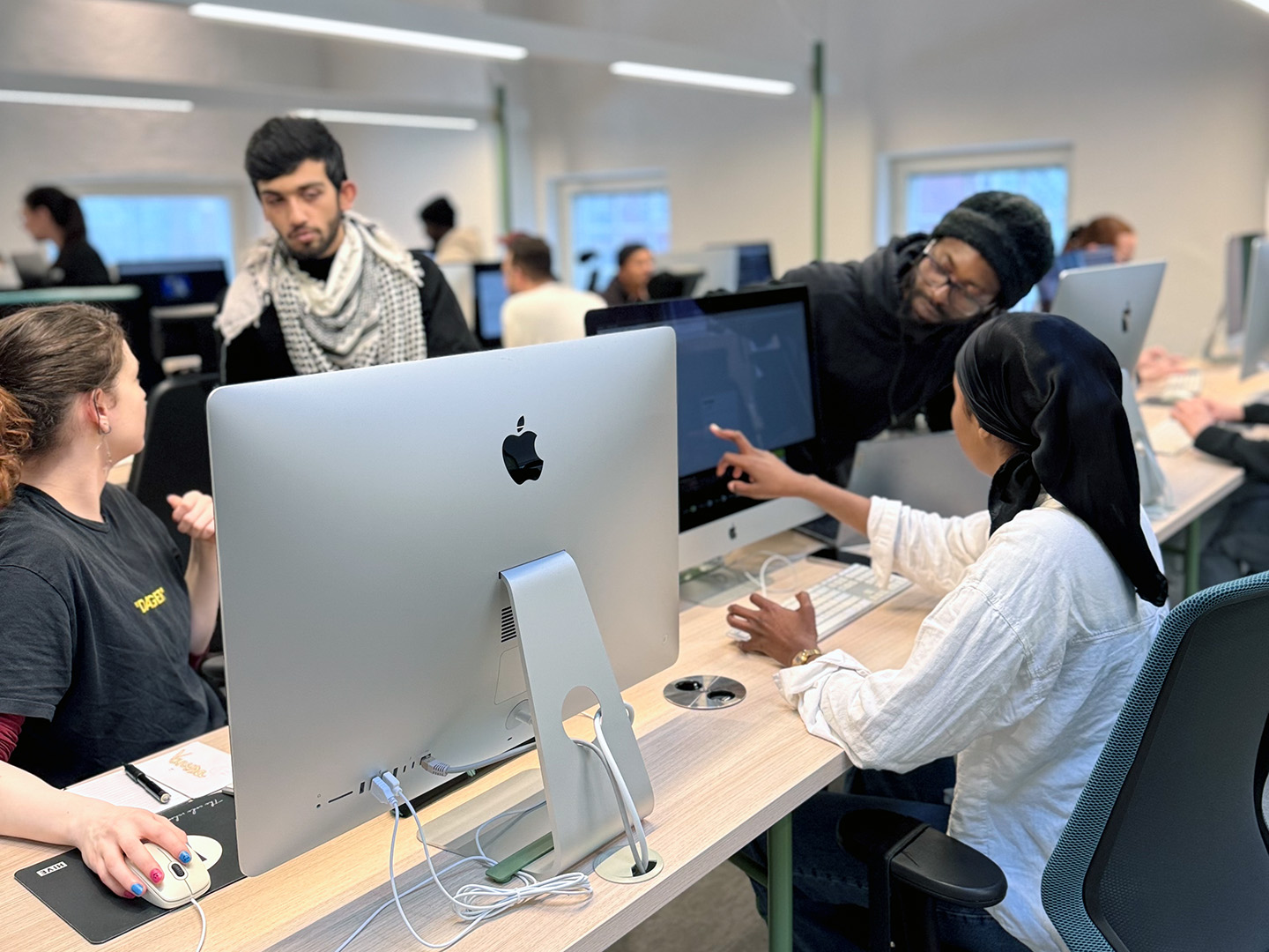 Selection Sprint applicants collaborating and reviewing work together at computers in the Hive workspace