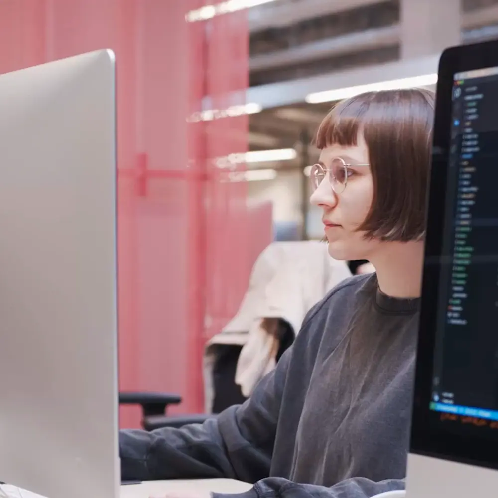 Person working on a laptop in a modern tech workspace at Hive Helsinki